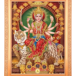 Può includere: Un dipinto colorato di una dea indù con otto braccia, seduta su una tigre bianca. È adornata con gioielli e fiori, ed è circondata da un'aureola di luce. Il dipinto è incorniciato in una cornice dorata.