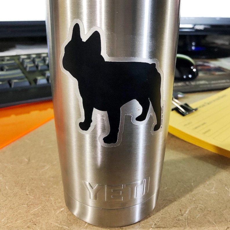 May include: A stainless steel Yeti tumbler with a black French Bulldog silhouette sticker. The sticker is applied to the front of the tumbler. The Yeti logo is visible at the bottom of the tumbler.