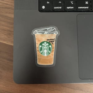 May include: A sticker of a Starbucks iced coffee cup with the text "emotional support" written on it.