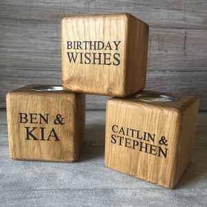 May include: Three wooden candle holders with engraved text. The top holder says "Birthday Wishes", the left holder says "Ben & Kia", and the right holder says "Caitlin & Stephen".