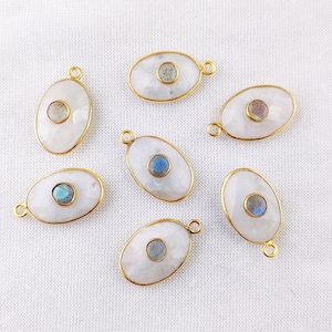 May include: Seven oval-shaped gold-plated pendants with a white moonstone base and a round iridescent labradorite gemstone in the center.