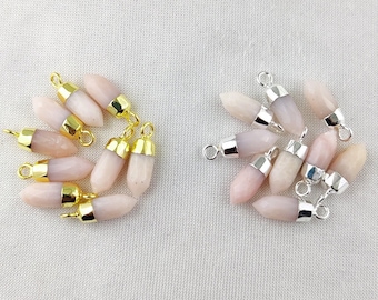 May include: A collection of pink opal gemstone pendants with gold and silver settings. The pendants are in the shape of a teardrop and have a smooth, polished finish.