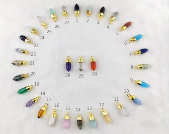 May include: Thirty gemstone pendants with gold-plated caps. Each pendant is shaped like a pointed crystal and features a different gemstone, including black tourmaline, aquamarine, tiger's eye, black rutile, chocolate moonstone, turquoise, lapis lazuli, prehnite, blue chalcedony, blue opal, rainbow moonstone, peach moonstone, aqua chalcedony, labradorite, pink chalcedony, pink opal, citrine, fluorite, green onyx, ruby zoisite, dalmatian jasper, dendrite opal, black onyx, white moonstone, rose quartz, amazonite, golden rutile, amethyst, crystal quartz, and carnelian.