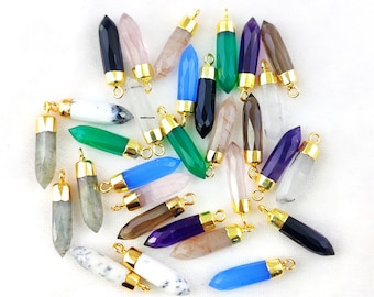May include: A collection of 20 gemstone pendant charms with gold-plated caps. The charms are in various colours, including green, blue, purple, pink, black, and white. Each charm is shaped like a pointed crystal.