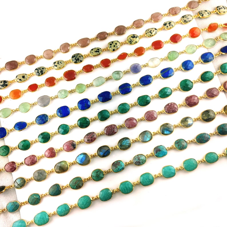 May include: A variety of gemstone chains with gold links. The chains feature different colored gemstones, including green, blue, red, and brown.