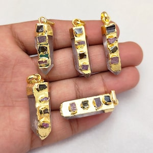 以下が含まれることがあります： さまざまな色の宝石がついた、金メッキされたクリスタルポイントペンダントが5つ。各ペンダントは、金メッキされたセッティングと5つの異なる色の宝石がついた、クリアなクリスタルポイントを特徴としています。
