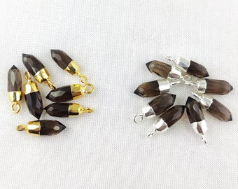 Puede incluir: Dos juegos de colgantes de punta de cristal de cuarzo ahumado con anillas de salto de oro y plata. Los colgantes miden aproximadamente 2,5 cm de largo.