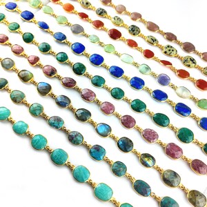 May include: A variety of gemstone chain bracelets with gold links. The bracelets feature different colors of gemstones, including turquoise, green, blue, pink, and brown.