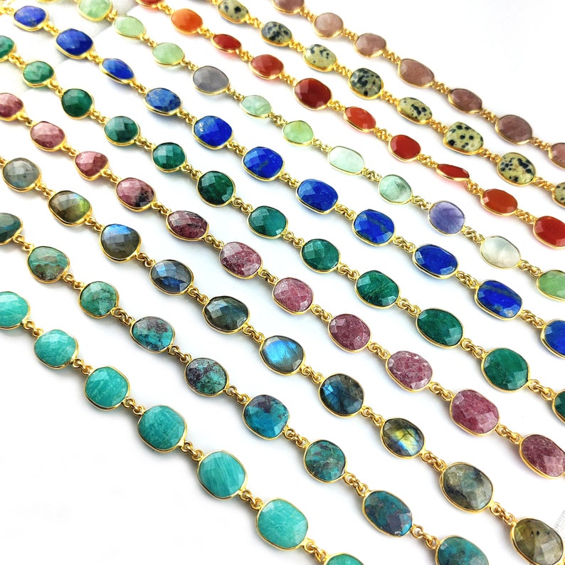 May include: A variety of gemstone chain bracelets with gold links. The bracelets feature different colors of gemstones, including turquoise, green, blue, pink, and brown.