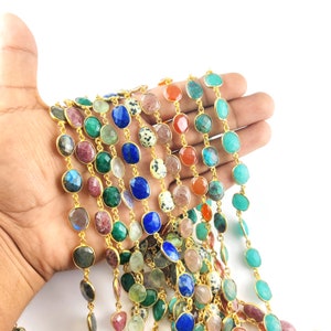 May include: A strand of gold chain with various gemstone beads, including lapis lazuli, carnelian, emerald, and turquoise.