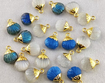 May include: Assortment of 18 gold-plated shell-shaped pendants with various gemstone inlays. The gemstones include blue labradorite, white moonstone, and blue chalcedony.
