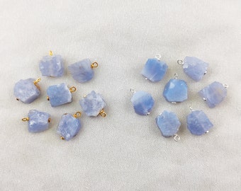 May include: A collection of 14 blue chalcedony gemstone pendants with gold and silver jump rings. The stones are irregular in shape and have a frosted finish.