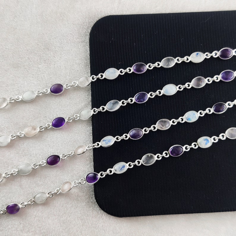 May include: Five silver bracelets with alternating oval-shaped amethyst and moonstone gemstones. The bracelets are displayed on a black surface.