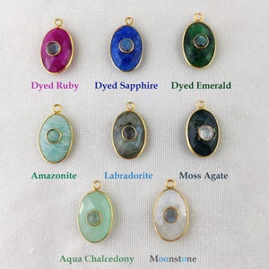 May include: Assortment of oval-shaped gemstone pendants with gold settings. The stones are dyed ruby, sapphire, emerald, amazonite, labradorite, moss agate, aqua chalcedony, and moonstone.