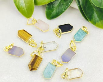 May include: Assortment of eight gemstone pendants with gold-tone accents. The pendants are shaped like elongated hexagons and feature various colors, including clear, purple, green, black, and brown.