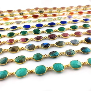 May include: A collection of gold chain necklaces with oval-shaped gemstone beads in various colors, including green, blue, pink, and brown.