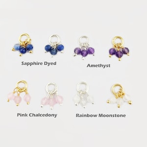 Puede incluir: Seis colgantes de amuleto diferentes, cada uno con tres cuentas de piedras preciosas. Los amuletos están hechos de oro y plata y presentan cuentas de zafiro teñido, amatista, calcedonia rosa y piedra lunar arcoíris.
