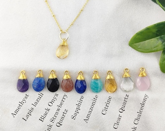 May include: A gold chain necklace with a variety of gemstone pendants, including amethyst, lapis lazuli, black onyx, pink strawberry quartz, sapphire, amazonite, citrine, clear quartz, and pink chalcedony.