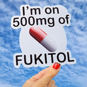 May include: White sticker with the text "I'm on 500mg of FUKITOL" in black. A red and white pill is pictured in the center of the sticker.