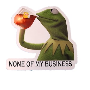 May include: Green Muppet character drinking from a glass of red liquid with a tea bag visible. The text "NONE OF MY BUSINESS" is below the character.