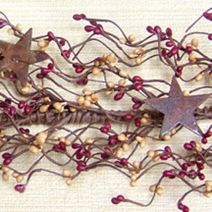 May include: A brown and beige berry garland with red berries and rusty star accents.