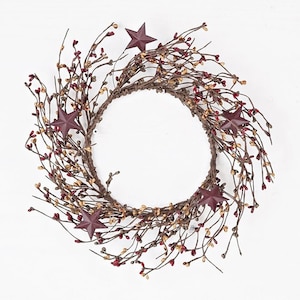 May include: A brown twig wreath with red berries and five burgundy metal stars. The wreath is approximately 12 inches in diameter.