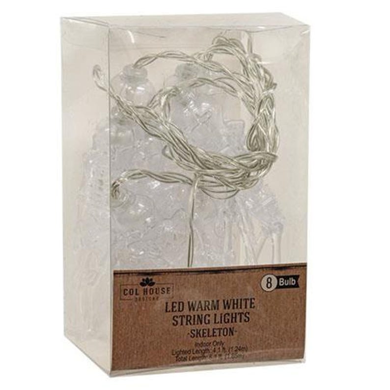 May include: A clear plastic box containing 8 LED warm white skeleton string lights. The label reads: COL HOUSE, 8 Bulb, LED WARM WHITE STRING LIGHTS, SKELETON, Indoor Only, Lighted Length 4.1 ft (1.24m), Total Length 6 ft (1.83m).