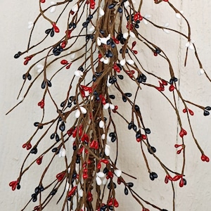 May include: A red, white, and blue berry garland with brown branches. The garland is made of artificial berries and branches.