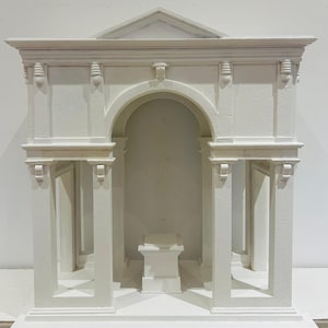以下が含まれることがあります： 丸いアーチと内部の正方形のプラットフォームを持つ、小さな古典的な寺院の白い石膏模型。モデルは、柱、ピラスタ、コーニスで詳細に作られています。