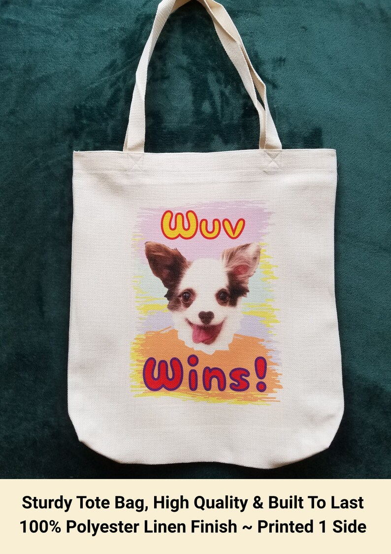 K&ouml;nnte beinhalten: Cremefarbene Tragetasche mit einem l&auml;chelnden Hunde-Motiv. Der Text "Wuv Wins!" ist &uuml;ber und unter dem Hund aufgedruckt. Die Tasche hat eine rechteckige Form und zwei Henkel.