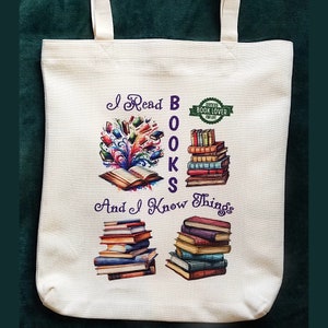 May include: A white canvas tote bag with a purple design that says "I Read Books And I Know Things". The design also includes a green circle with the text "Certified Book Lover For Life" and an illustration of a book with colorful pages exploding out of it.