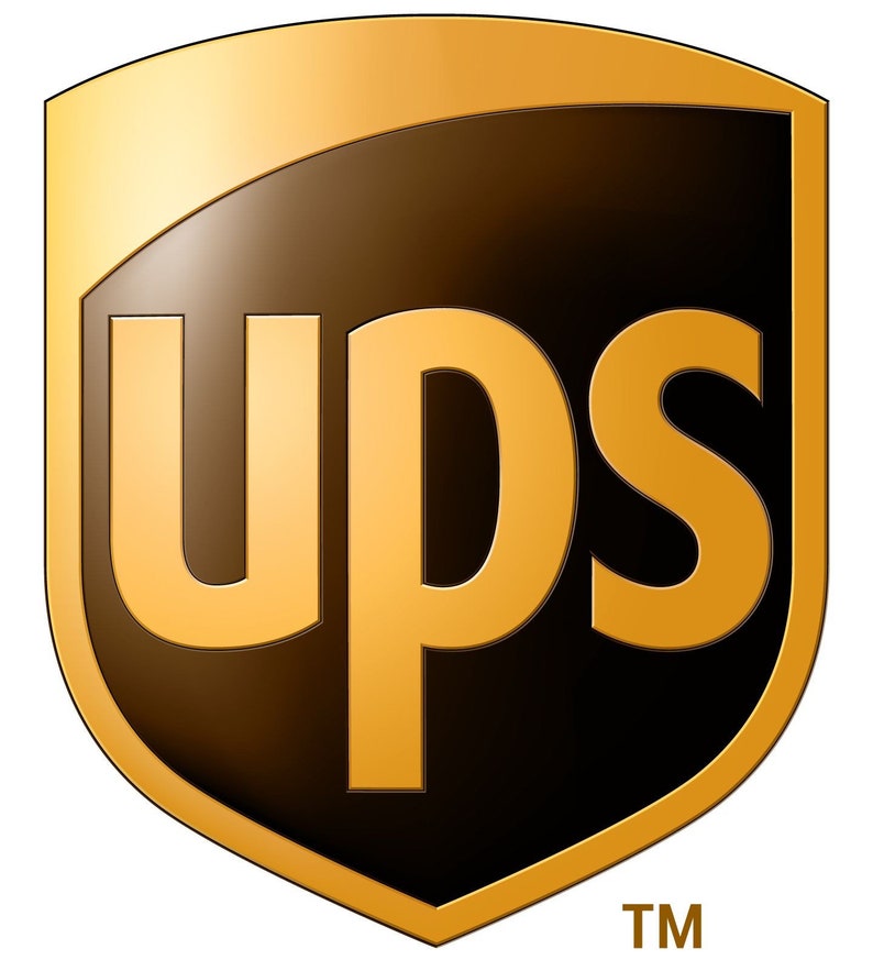 Op de afbeelding: Een bruin schildvormig logo met het woord "UPS" in gouden letters. Het logo heeft een gouden rand en een gouden achtergrond. De letters "TM" staan in wit onder het logo.