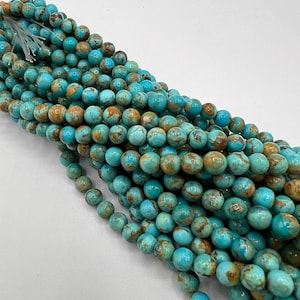 May include: A strand of turquoise blue and brown round beads. The beads have a mottled pattern and are approximately 6mm in diameter.
