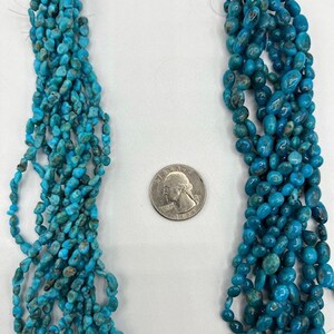 May include: Two strands of turquoise beads, one with small, irregular shaped beads and the other with larger, oval shaped beads. The strands are labelled #1 and #2.
