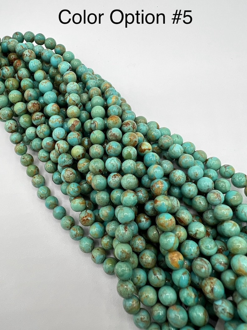 May include: A strand of turquoise blue beads with brown and gold marbling. The beads are round and smooth, and they are strung together on a clear thread.