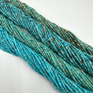 May include: A strand of turquoise beads, with a light blue and green color, in a tube shape. The beads are approximately 4mm in diameter and are strung on a thin wire.
