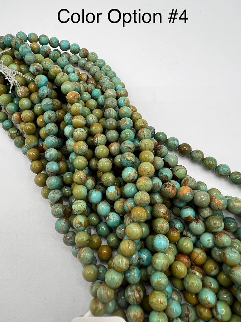 May include: A strand of turquoise-colored beads with brown and green marbling. The beads are round and smooth, and they are strung together on a clear thread.