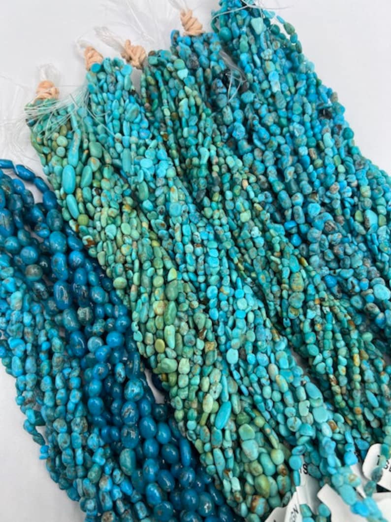 May include: A collection of turquoise gemstone beads in various shades of blue and green. The beads are strung on multiple strands and are ready for jewellery making.