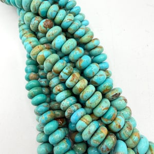 May include: A strand of round, disc-shaped turquoise beads featuring a vibrant sky-blue color with natural brown matrix veining throughout. The beads are arranged in a dense, vertical cluster, showcasing their smooth, polished surfaces and consistent size.
