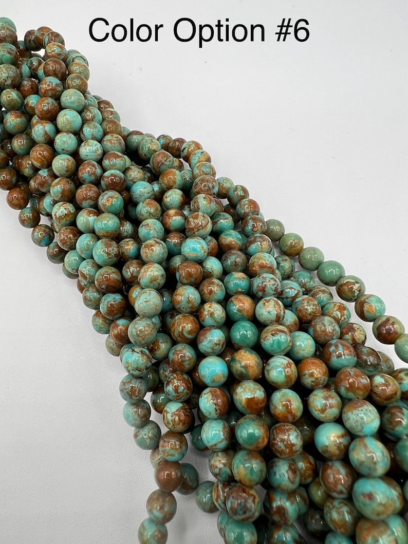 May include: A strand of turquoise blue and brown round beads. The beads have a marbled pattern and are strung together on a clear thread.