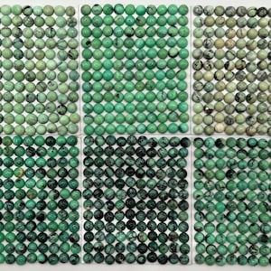 May include: Six sheets of green turquoise cabochons, each sheet containing 36 cabochons, for a total of 216 cabochons.