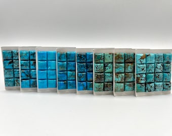 Könnte beinhalten: Ein Satz von acht Türkis-Cabochons, jeder mit einem anderen Blauton und Grün. Die Cabochons sind in einer Reihe auf einem weißen Hintergrund angeordnet.