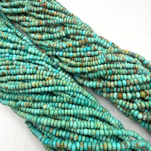 May include: Two long strands of small, round, disc-shaped turquoise beads. The beads feature a vibrant teal and blue color palette with natural brown matrix inclusions, creating a varied, mottled appearance across the entire length of the strands.