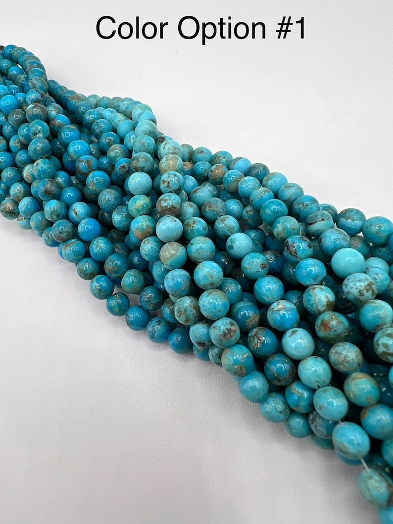 May include: A strand of turquoise blue beads with brown and white marbling. The beads are round and have a smooth, polished finish.