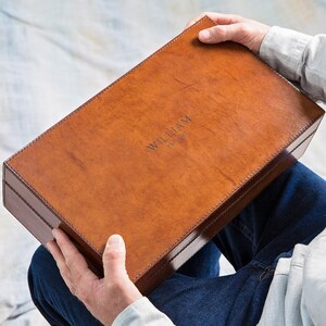 May include: A brown leather box with the name "WILLIAM" embossed on the top.
