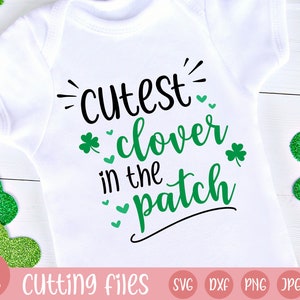 May include: White baby onesie with the text "cutest clover in the patch" in black and green. The design includes shamrocks and hearts. The bottom of the image has the text "cutting files" and file type icons.