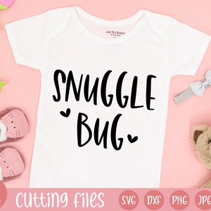Puede incluir: Body de bebé blanco con la frase "SNUGGLE BUG" en escritura negra. La imagen incluye accesorios para bebés como una diadema gris con lazo, un oso de peluche y zapatos rosas. Las palabras "Cutting Files" están en la parte inferior.