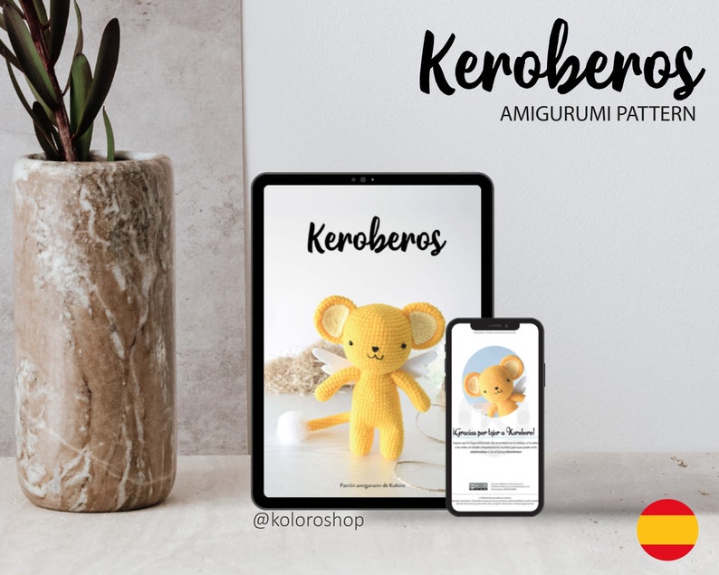 May include: A digital tablet and a smartphone display a crochet pattern for a yellow amigurumi toy named Keroberos. The pattern includes instructions for making the toy and a picture of the finished product. The text on the screen reads "Keroberos Amigurumi Pattern".