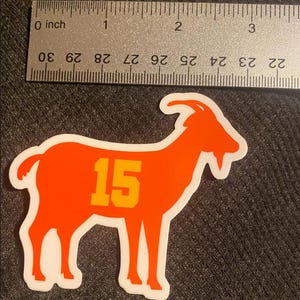 May include: Orange goat silhouette sticker with the number 15 in yellow on the side.