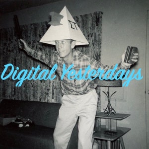 May include: A man wearing a white pyramid hat with the letters "ET" on it, holding a black object in one hand and a small box in the other. The text "Digital Yesterdays" is written in blue cursive letters across the bottom of the image.